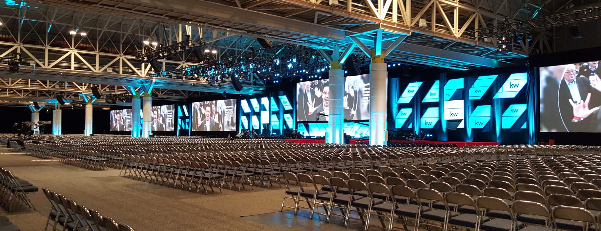 A large room with many chairs and a big screen